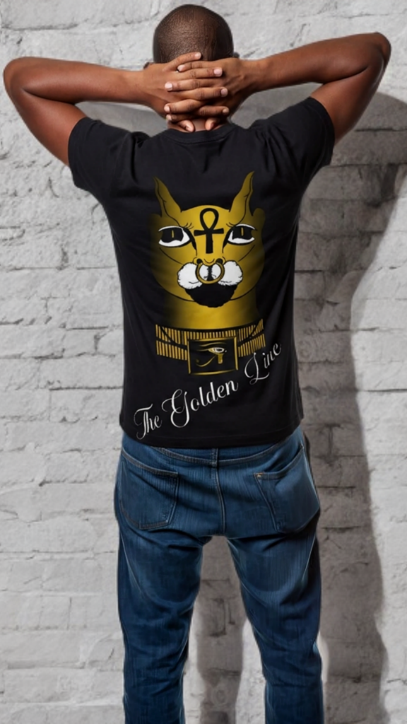 Person wearing a black t-shirt with a graphic design of a cat and text, standing against a light gray brick wall.