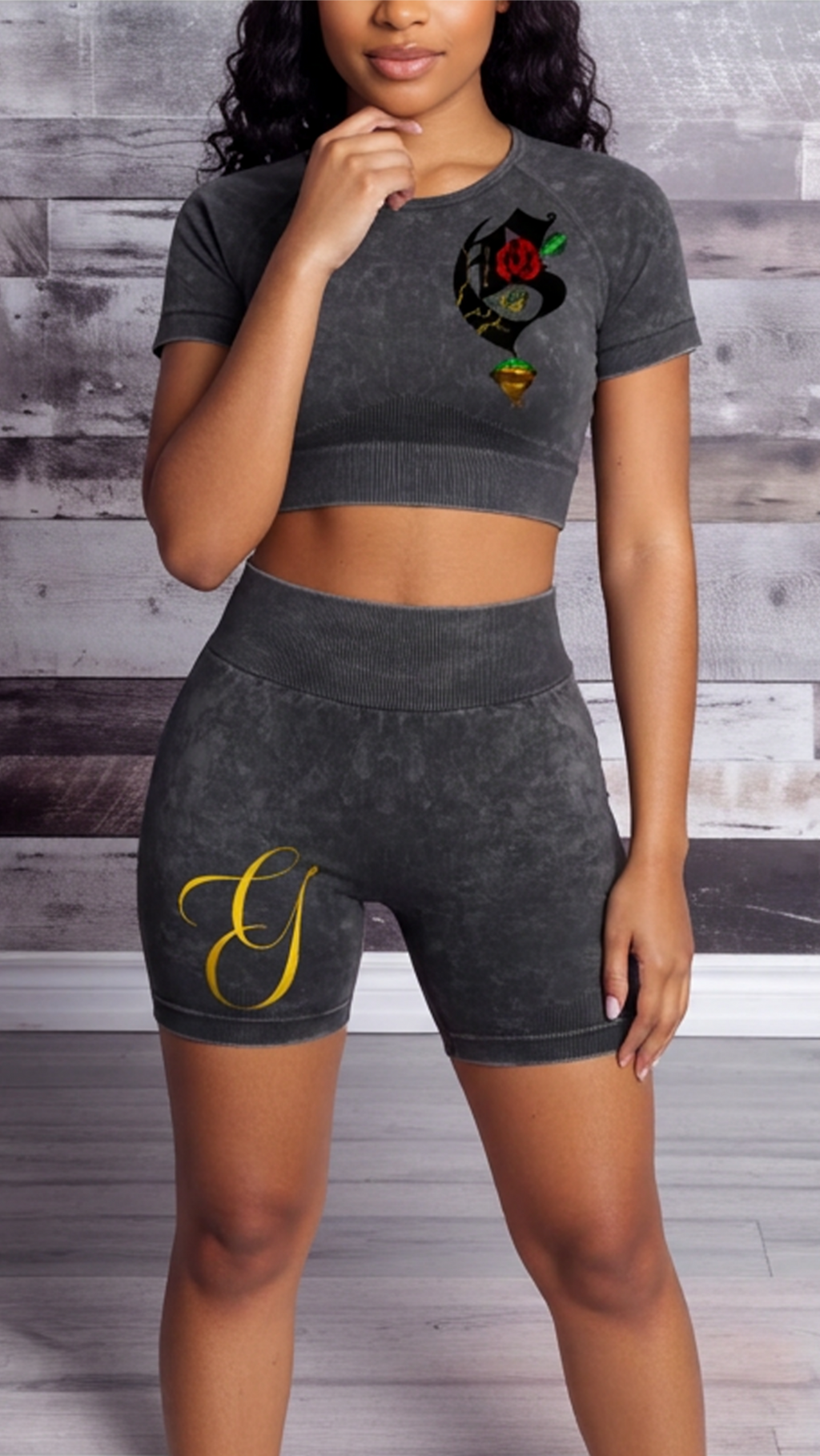 Woman wearing a dark gray athletic outfit with a design on a wooden background