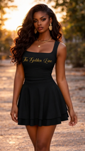 Woman wearing a black dress with 'The Golden Line' branding in an outdoor setting.