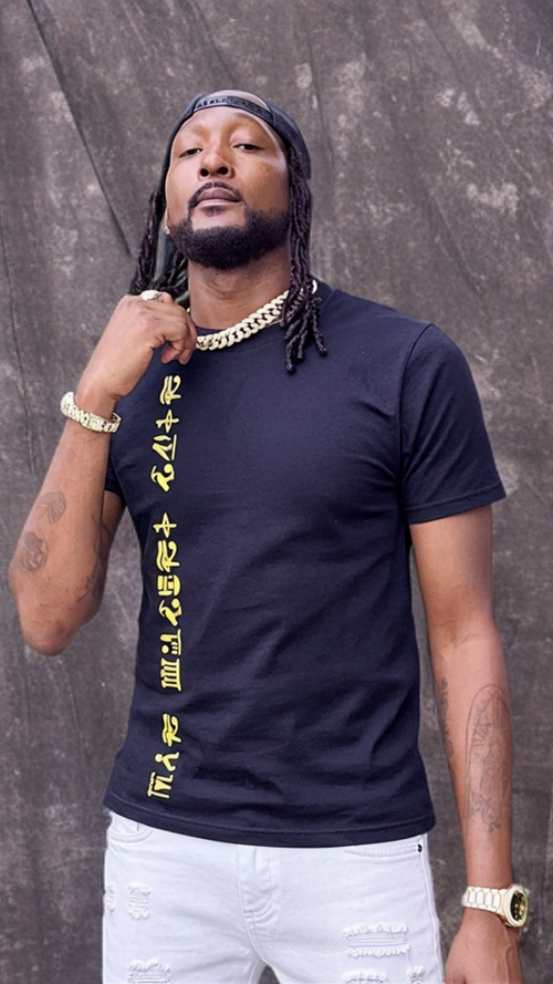 Man wearing a black t-shirt with yellow text against a textured gray background