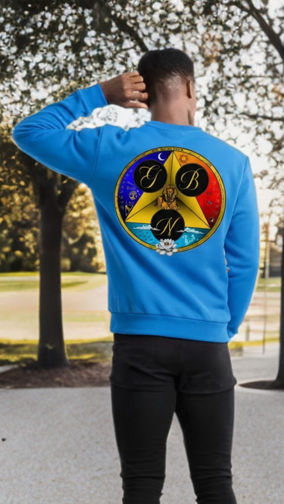 Person wearing a blue sweatshirt with a colorful emblem on the back, standing outdoors.