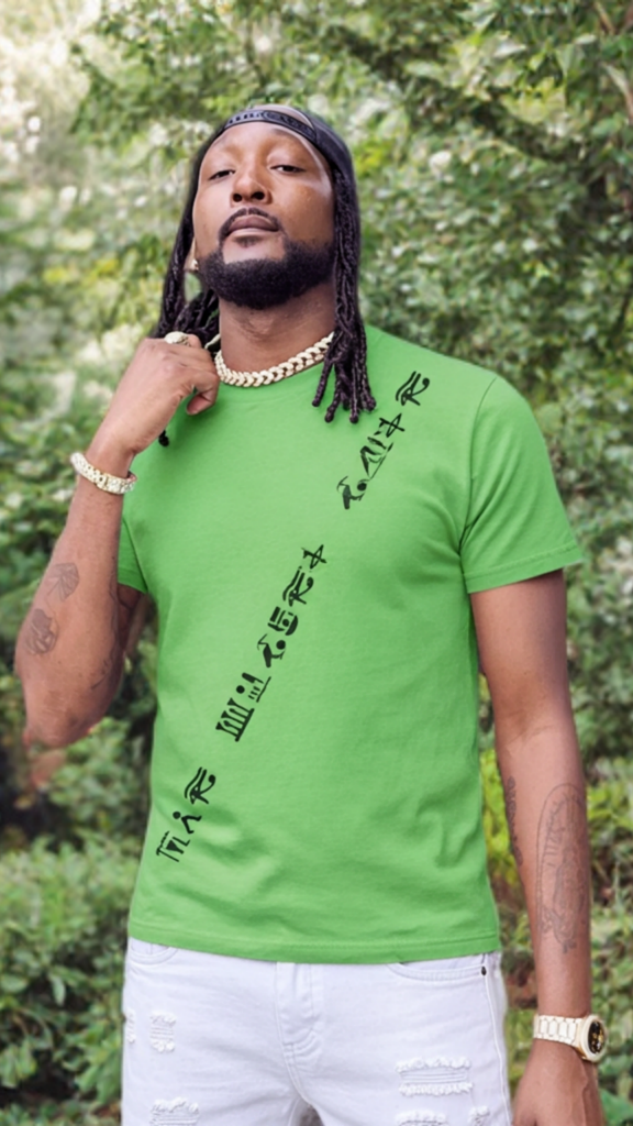 Man wearing a green t-shirt with black text standing in a forest