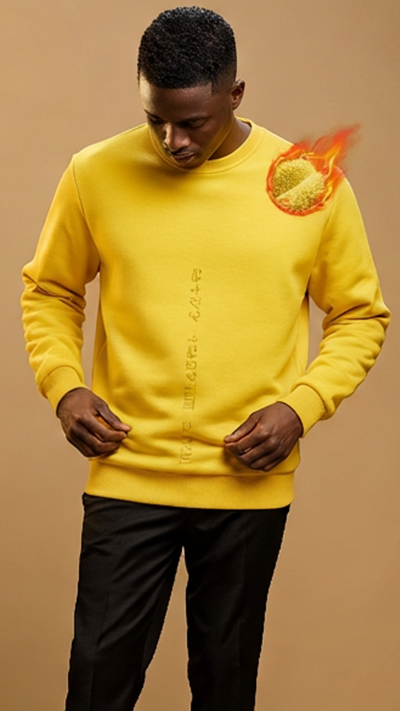 Man wearing a yellow sweater and black pants on a brown background