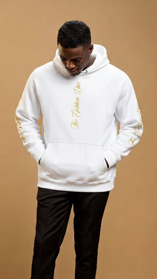 Person wearing a white hoodie with gold accents on a brown background