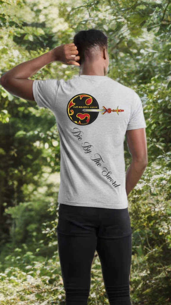 Person wearing a white t-shirt with a design and text on the back, standing in a forest.
