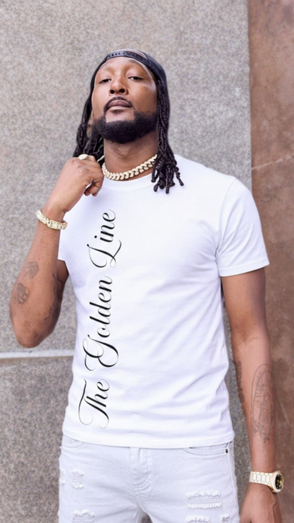 Man wearing a white t-shirt with text, standing against a textured wall.