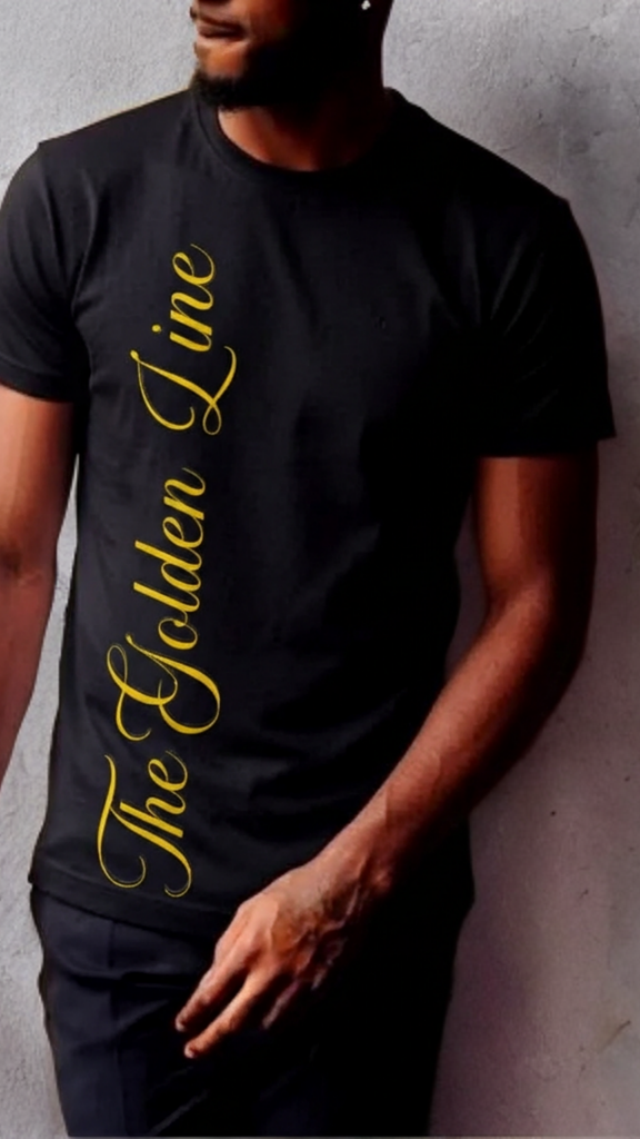 Person wearing a black t-shirt with 'The Golden Line' text in gold against a gray wall.