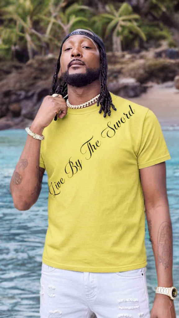 Man wearing a yellow t-shirt with text by a beach