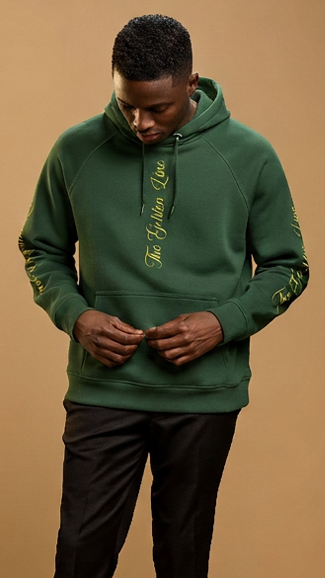 Man wearing a green hoodie with text on a brown background